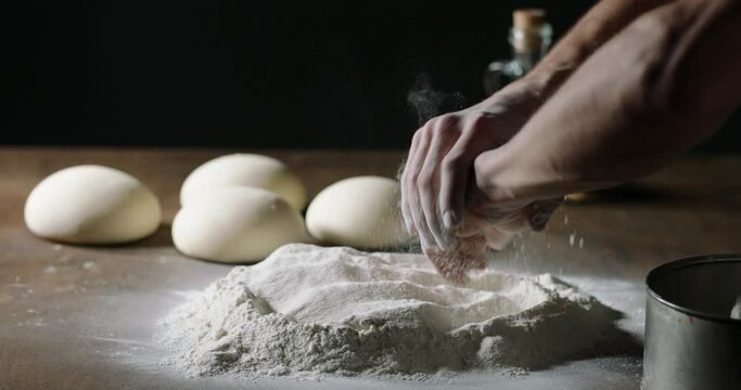 Close up shot of hands dusting off flour. Preparation for making bread in bakery. Cooker checking ingredients. Food and drink 4k footage