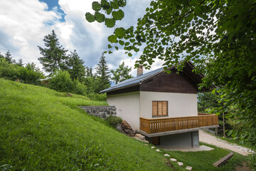Residential house, a slovenian chalet building, in the middle of a mountain glade, a clearing in...