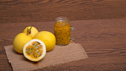 yellow passion fruit with pulp jug on brown wooden table