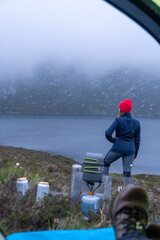 First-person view from the tent. The concept of travel and camping in the wild. Shore, gasfire. Travel equipment. Active lifestyle