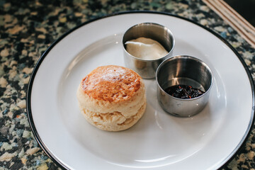 Butter scones with strawberry Jam and Clotted Cream on the table. Traditional English afternoon tea horizontal.