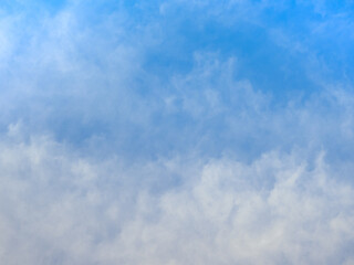 A peaceful scene of a clear blue sky softly blanketed by wispy white clouds, evoking a sense of calm and tranquility.

