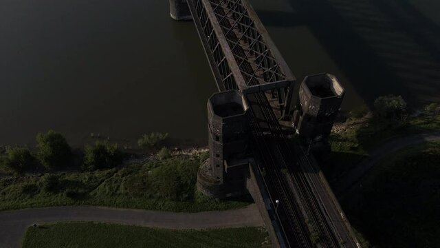 Aerial reveal of Rhine river cargo ship passing under Urmitzer Railway Bridge, Germany