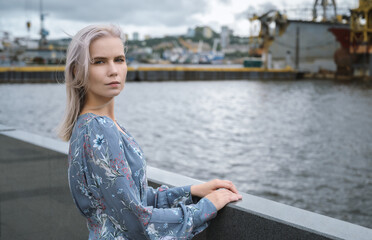 Woman in blue dress enjoys sea shore.