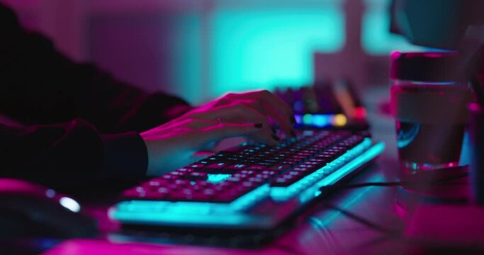 computer hands typing on keyboard programmer coding hacking data on internet cyber crime information hack by anonymous hacker using rgb gaming keyboard with blue backlight