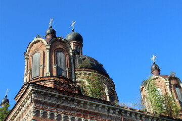 Fototapeta premium The dome of an old abandoned church stands against the summer sky.