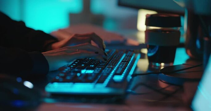 computer hands typing on keyboard programmer coding hacking data on internet cyber crime information hack by anonymous hacker using rgb gaming keyboard with blue backlight