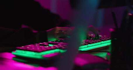 computer hands typing on keyboard hacking data on internet cyber crime information hack by anonymous hacker using rgb gaming keyboard with green backlight