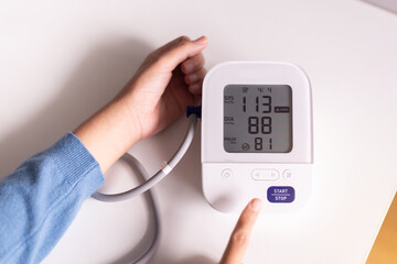 Patient woman using blood pressure and heart rate monitor for yourself at home