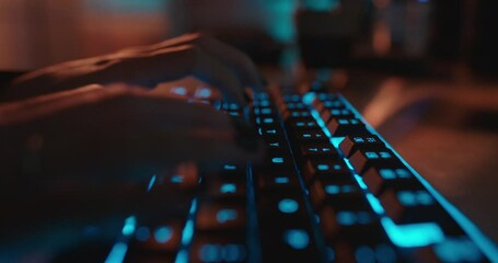 close up hands typing on keyboard programmer coding software gamer using keyboard with blue backlight playing game at night