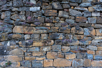 Wall of real stone for background, typical construction of the rural world and of the mountain areas.