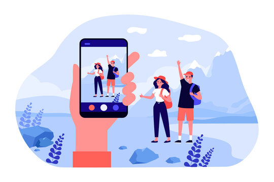 Hand holding smartphone, taking pictures of young travelers. Flat vector illustration. Man and woman posing with backpacks and mountain landscape on background. Travel, trip, photo, technology concept