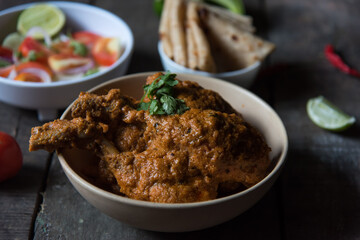 North Indian delicacy murg makhani or butter chicken prepared with chicken breast, onion, garlic and whole Indian spices in a bowl. Close up.	
