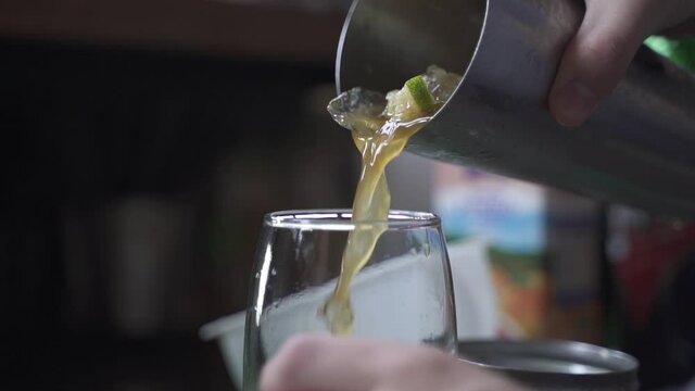 Close up of Bartender pouring alcoholic Cynar Drink in glass at party,slow motion