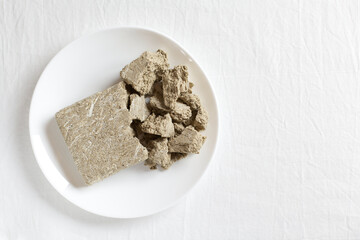 Halva dessert in a plate on a white background with copy space. View from above
