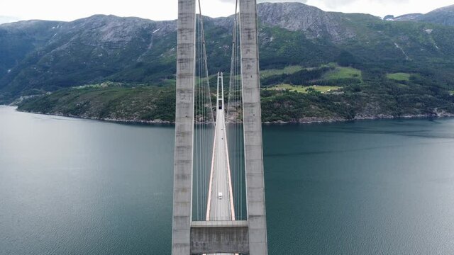 Spectacular Hardanger-bridge aerial - Moving ahead in between bridge wires and concrete columns - Panoramic view of bridge from high altitude - One of worlds largest suspension bridges - Norway