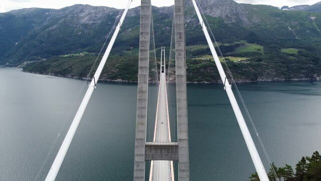 Upward moving aerial with panoramic view ower Hardanger bridge - Passing close to cables holding bridge - Massive suspension bridge Norway