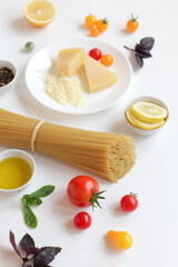 Ingredients for Italian pasta on a white background. Vegetarian food. Homemade food. Close-up copy space.
