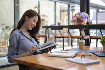 Fototapeta premium Peaceful Asian woman reading a book in coffee shop.