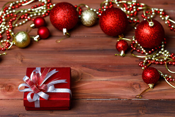 Close up shot of gift present box wrapped with ribbon bow placed on old dark wooden table decorated with xmas ornaments props