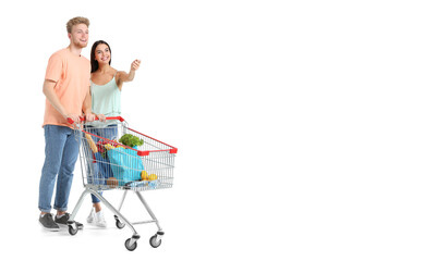 Young couple with shopping cart on white background with space for text