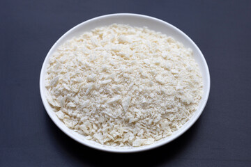 Bread Crumbs in white plate on dark background.