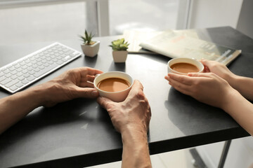 Woman and man with cups of coffee in office