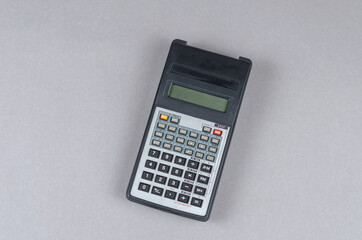 Scientific Calculator against gray background. An electronic computing device for performing operations on numbers or algebraic formulas.