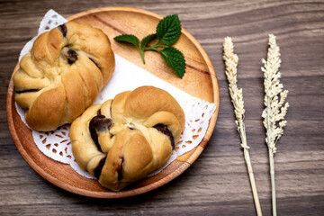red bean bread, roti kacang merah, indonesian dish on wooden table decorated with dried flowers