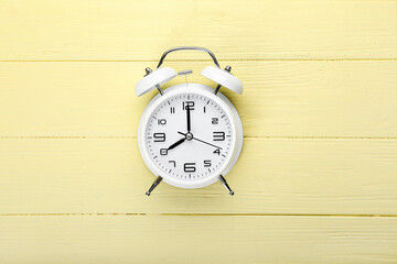 Stylish alarm clock on color wooden background