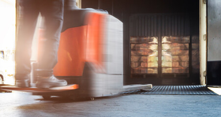 Motion Blur of Workers Driving Electric Forklift to Unloading Packaging Boxes Inside Container....