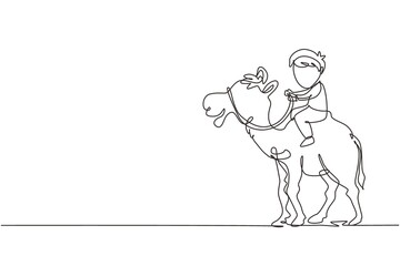Fototapeta na wymiar Single one line drawing happy little boy riding camel. Child sitting on hump camel with saddle in desert. Kids learning to ride camel. Modern continuous line draw design graphic vector illustration
