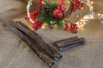 Festive composition with dog treats on sacking. Dried beef stomach. Beef tripe of various size. Natural Chewable Pet Treats. Christmas wreath in background. Selective focus.