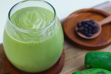 Avocado Coffee smoothie on clear glass on isolated background, with avocado fruits and coffee beans. 