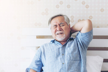 Senior Asian man , old man he wake up and sat on the bed , He had pain in the nape of his neck...