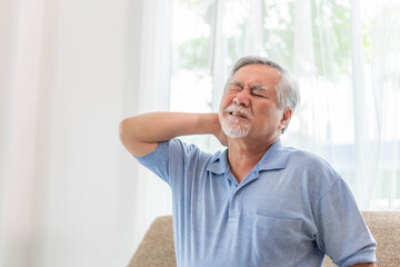Senior Asian man , old man he wake up and sat on sofa , He had pain in the nape of his neck caused...