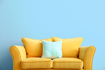 Comfortable sofa near color wall