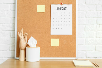 Modern workplace with sticker board near brick wall