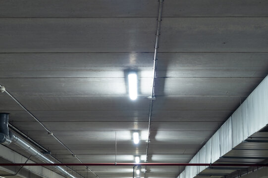 Ceiling Of A Garage With Fluorescent Tube Lamps. White Light In The Parking Lot Of A Shopping Center. 