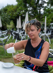 Fototapeta premium mujer tomando cafe en una terraza de un bar al aire libre
