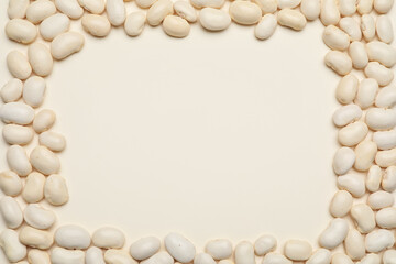 Frame made of raw beans on white background