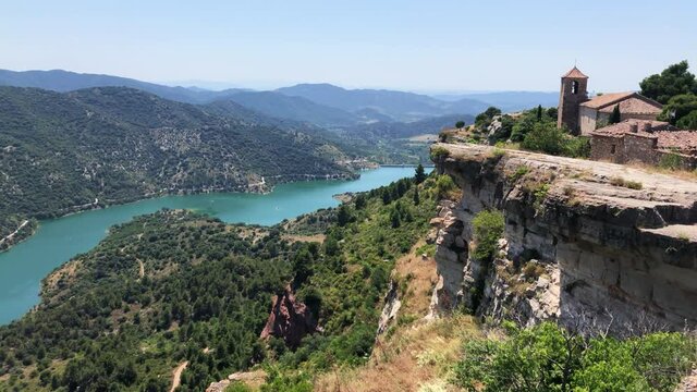 Pan shot of Siurana Town in Catalonia, Spain. Panoramic view of the Siurana church and the Siurana reservoir. Panoramic view of el Panta de Siurana in a sunny day.
