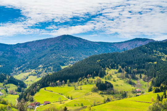 Germany, Schwarzwald village houses surrounded by beautiful forest covered mountains nature landscape perfect for hiking and tourism, aerial panorama view above © Simon