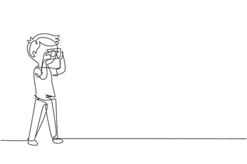 Single continuous line drawing boy taking picture with pocket camera. Photographers taking photo with digital cameras. Photography hobbies. Dynamic one line draw graphic design vector illustration