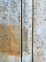 very old metal plates of blue color with a crossbar with peeling paint covered with rust