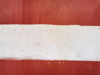 texture of old painted rusty red wall or garage door with peeling and cracked paint and corrosion and white stripe