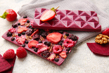 Handmade chocolate bars with fruits, berries and nuts on light background, closeup