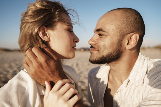Portrait of happy young couple in love embracing each other on beach