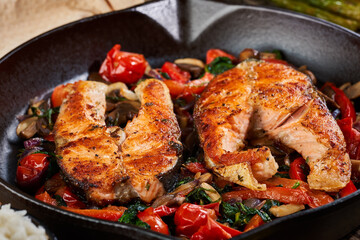 Salmon with vegetables cooked in a cast iron skillet