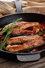 Salmon with vegetables cooked in a cast iron skillet